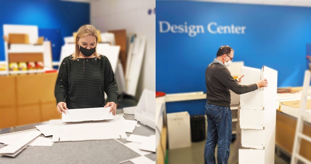 Two designers from the Smurfit Kappa Drogenbos team working with their hands on the design of a point of sale display