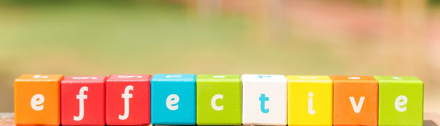 A beautiful colourful picture with wooden cubes in different colours that have a letter on each side. The cubes next to each other spell the word 'effective'